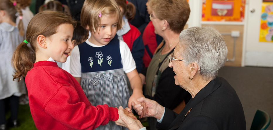 photo of two young girls holding hands with a senior woman
